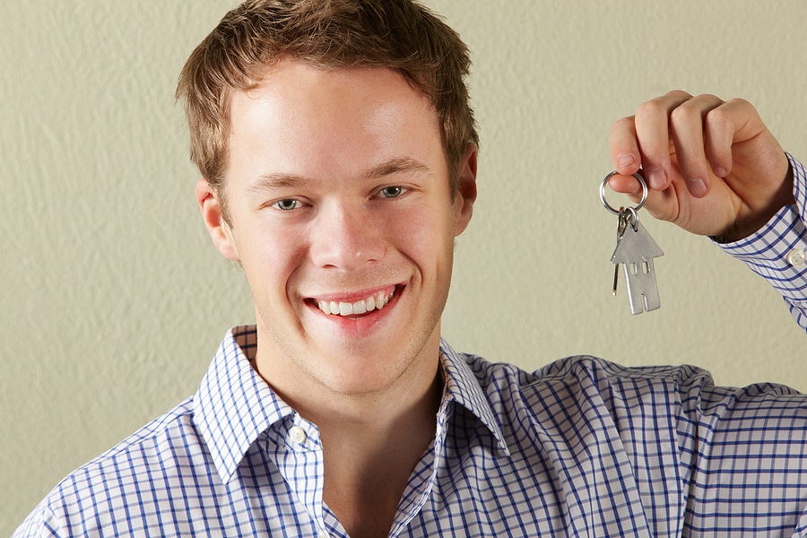 Studio Shot Of Young Man Holding Keys To First Home