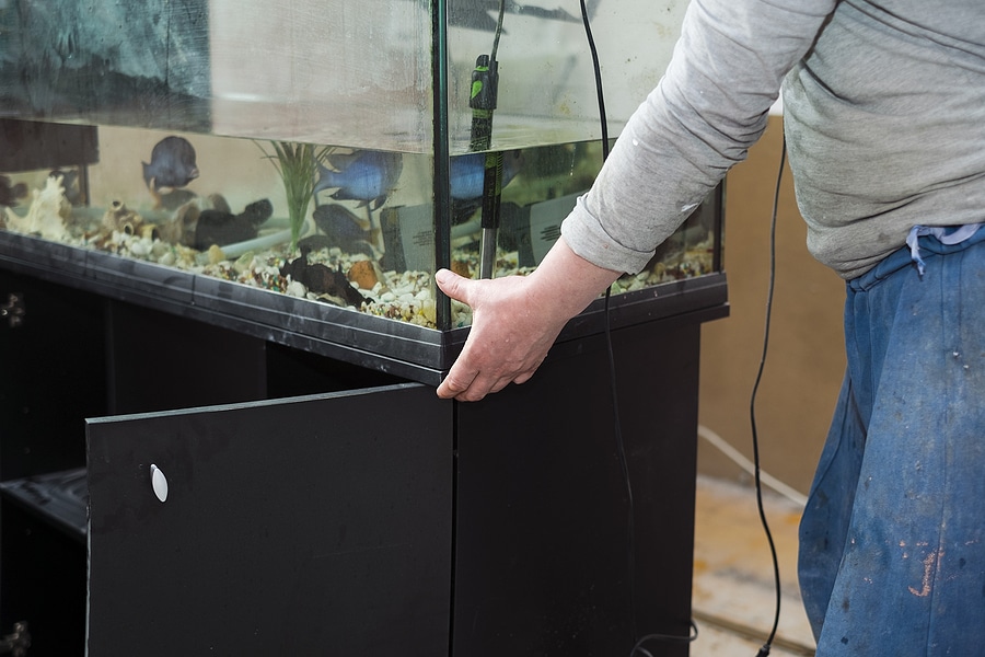 A Worker Moving A Fish Tank In A Room Under Renovation