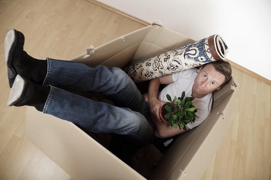 man in a cardboard box with items