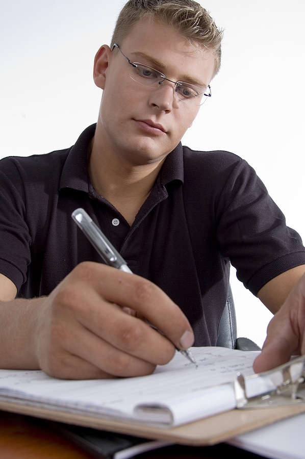 Man Writing On Notepad